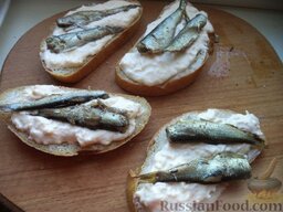 Горячие бутерброды со шпротами и сыром: На каждый ломтик положить по (1-2) малень­кой рыбке.