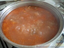 Харчо по-грузински: Добавить в казан замоченный рис, пассерованный лук, довести до готовности (около 20 минут). Заправить суп соусом ткемали, томатом.