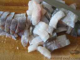 Пирог из сырой рыбы с луком и рисом: За 20-30 минут до приготовления пирога подготовить рыбу, лучше жирную. Нарезать рыбное филе поперек полосками толщиной 1-1,25 см.