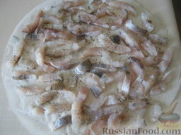 Пирог из сырой рыбы с луком и рисом: Каждую полоску немного посолить с обеих сторон (всего уйдет 1-2 ч. ложки), поперчить (1-2 щепотки), выложить на пергамент, соответствующий размеру пласта теста на противне, и оставить на 30-40 минут. Для равномерного распределения жира в пироге, полоски рыбы следует уложить так, чтобы жирная часть чередовалась с нежирной.