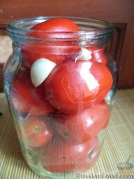 Соленые помидоры с чесноком: На дно банки уложите очищенные зубчики чеснока, сверху — помидоры, которые следует также равномерно пересыпать чесночными дольками.