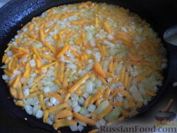 Суп с колбасой и рисом: Разогреть сковороду, налить растительное масло. В горячее масло выложить лук и морковь. Морковь обжарить в растительном масле вместе с луком на среднем огне, помешивая, 2-3 минуты (до золотистости).