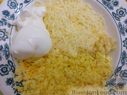 Яйца, фаршированные сыром и чесноком: Измельченные желтки соединить с остальными продуктами. Смешать их с сыром, чесноком и майонезом до однородности.