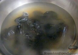 Салат «Нежность»: Чернослив вымойте, выложите в кастрюлю. Вскипятите чайник, залейте чернослив кипятком. Сварите до готовности на среднем огне (около 5 минут).