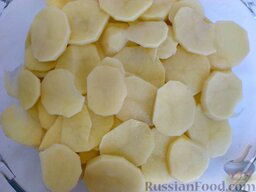 Картошка по-французски: Положите в кастрюлю или другую емкость для запекания половину всей картошки (это будет первый из двух слоев).