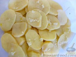 Картошка по-французски: Первый слой посыпьте мелко нарубленным  (раздавленным) чесноком, смешанным с солью.     Выложите второй слой картошки (оставшуюся половину) и также смажьте чесноком.