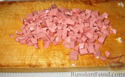 Салат "Мой Цезарь": Вареную колбасу нарезаем кубиками.