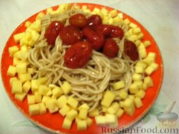 Спагетти с  солёными помидорами: Кубики сыра положить по краю тарелки и посыпать петрушкой.