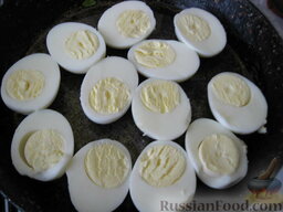 Запеченные яйца под томатным соусом с лососем: Яйца разрезаем вдоль и выкладываем желтками вверх на смазанную поверхность, в которой будем запекать.