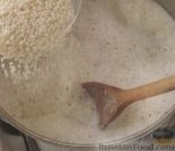 Рисовый пудинг с сушеными вишнями: В четырехлитровую кастрюлю налить молоко, высыпать сахар. На среднем огне довести до кипения. Высыпать рис. Уменьшить огонь до минимального.
