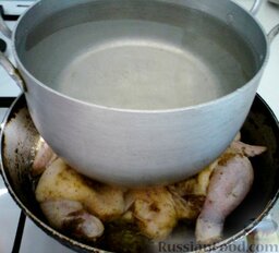 Цыплята табака: Выкладываем цыплёнка на разогретую сковороду с маслом. Сверху нужно придавить каким-то грузом, например, кастрюлей с водой.   Жарим цыпленка табака 15-20 минут на одной стороне, потом 15-20 минут на другой стороне, до золотистой корочки.