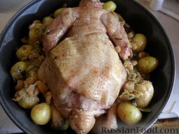 Курица с начинкой и молодым картофелем: Фаршированная курица с картофелем перед отправкой в духовку.