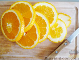 Апельсиновый лимонад / Безалкогольный крюшон: 4. Апельсин нарезать кружочками. Выложить их в кувшин с остывшим сиропом.