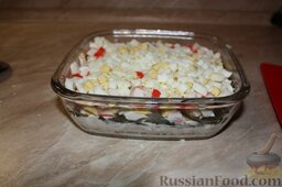 Салат "Черное море": Далее нарезать мелкими кубиками яйца и крабовые палочки, выложить на слой капусты, покрыть еще слоем майонеза.