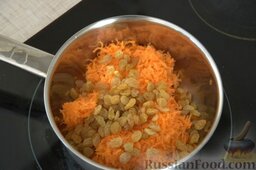 Морковные сладкие шарики: Высыпаем морковь и изюм в кастрюльку, ставим на небольшой огонь.