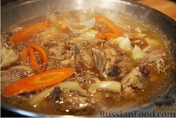 Дакжим (курица с овощами по-корейски): Открыть крышку и добавить морковь и лук. Продолжать готовить еще 10 минут, не накрывая крышкой.