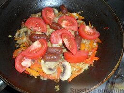 Лечо с копчеными колбасками: Добавляем помидоры и колбаски.