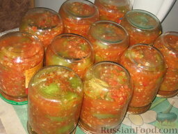 Зеленые помидоры в аджике: Разложим горячий салат в банки и закатаем их. Укутаем банки до полного остывания.  Приятного аппетита!