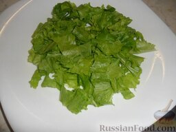 Тёплый салат из куриной печени: Раскладываем кусочки печени по краям тарелки, в середину рвём листья салата.
