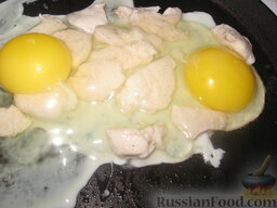Яичница с куриным филе: Вбить на сковороду к курице яйца. Жарить 3 минуты под крышкой.