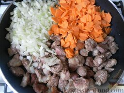 Мясное рагу с овощами: Добавляем лук и морковь к мясу на сковороду.