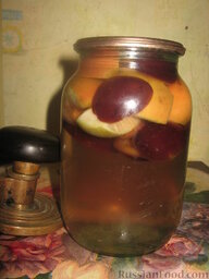 Компот из слив и яблок на зиму: Вскипятить воду. Залить ею фрукты. Накрыть банку крышкой и оставить на 15 минут.