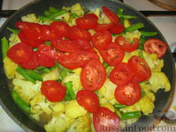 Овощное карри с цветной капустой: Помидоры нарезать тонкими полукружиями и добавить к овощам. Перемешать и потушить еще пару минут.