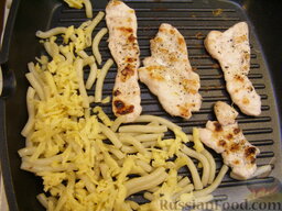 Куриное филе на гриле с макаронами (к ужину): Когда филе поджарится с одной стороны (2-3 минуты), переворачиваем мясо, выкладываем на сковороду отварные макароны, притрушиваем их сыром.