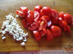 Овощное рагу вегетарианское: Тем временем почистить и порезать мелко чеснок. Помыть и нарезать помидоры.