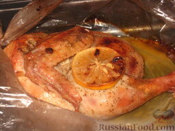 Курица с лимоном: Отправить противень в разогретую до 220 градусов духовку на 1 час и запекать курицу с лимоном до румяной корочки.