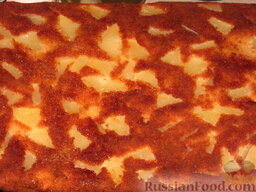 Пирог ананасовый: Слегка остудить пирог в противне. Вынуть вместе с пекарской бумагой и перевернуть пирог с ананасами на блюдо. Аккуратно снять бумагу. Нарезать.
