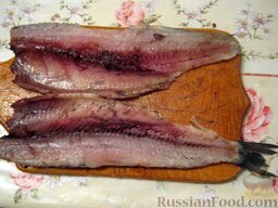 Вкусная селедка с луком: Разрезать рыбу на две половины.