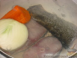 Рыба отварная с лимонным соусом и картофелем на гарнир: Очистить репчатый лук и морковь, промыть, разрезать пополам. Добавить к рыбе. Довести до кипения, снимая шум.