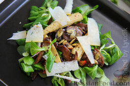 Теплый салат с грибами и кукурузой: Пармезан крупно настругать при помощи острого ножа, выложить поверх салата. Сверху полить заправкой. Теплый салат с грибами готов!