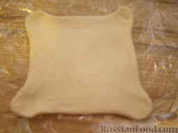 Пирожки-конверты из слоеного теста: Готовое слоеное тесто разворачиваем в пласт. Режем на квадратики со стороной, примерно, 6-7 см.  Когда тесто полностью разморозится, раскатываем его до толщины 0,5 см. Растягиваем уголки.