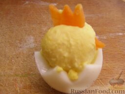 "Цыплята" из перепелиных яиц: Влажными руками скатать из желтков маленькие шарики.  Из тонких ломтиков морковки вырезать гребешки. А оставшиеся треугольнички использовать как клювики.  Воткнуть гребешки и клювики в шарики из желтка и усадить 