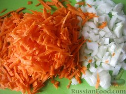 Суп с колбасой  "Для ленивой хозяйки": Тем временем очистить и помыть лук и морковь. Лук нарезать кубиками. Морковь натереть на терке.