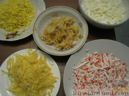 Салат "Мимоза" с крабовыми палочками: Натереть на терке твердый сыр, крабовые палочки, отдельно яичные белки и желтки, яблоко.