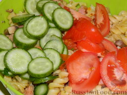 Макаронный салат с ветчиной: Помидор и огурец помойте, обсушите бумажным полотенцем.   Нарежьте огурец кружочками, а помидор дольками. Добавьте овощи в салат.