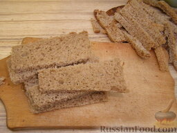 Хлебная запеканка с фаршем: Хлеб нарезать толщиной 1 см. Срезать корки. Каждый кусочек разрезать пополам.