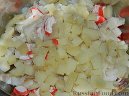 Салат из кальмаров и рыбы "Гавань": Картофель залейте кипятком, отварите в мундире до готовности (20-25 минут), посолив и добавив щепотку сахара. Охладите и очистите. Нарежьте кубиками.