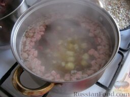 Солянка с колбасой: А затем выложить картофель в кипящий бульон с копченостями. Варить около 15 минут.