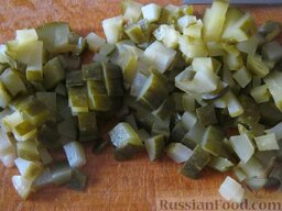 Солянка с колбасой: Пока картофель варится, взять маринованные огурцы и нарезать маленькими кубиками.