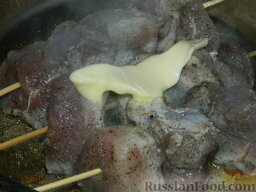Шашлык на сковороде: Сверху на мясо добавить сливочное масло.