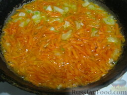 Хек, тушенный в томатном соусе: Разогреть  другую сковороду или помыть сковороду от рыбы. Налить растительное масло. Выложить лук и морковь. Обжарить, помешивая, на среднем огне 2-4 минуты.