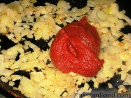 Солянка старомосковская в горшочках: Пассеруем мелко порезанный лук и добавляем к нему томатную пасту. Жарим вместе 2 минуты на умеренном огне.
