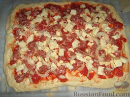 Пицца с домашними колбасками и рукколой: Выкладываем моцареллу, лук, порезанный четвертькольцами, сырые измельченные домашние колбаски.