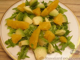 Салат из авокадо с апельсинами: Целые и резаные апельсиновые дольки разложить рядом с кусочками авокадо.