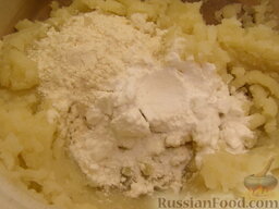 Клецки из отварного картофеля с сырной начинкой: Добавить муку и крахмал. Перемешать.