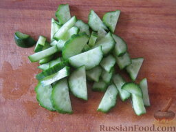 Салат из семги с помидорами: Огурцы свежие помыть и нарезать кусочками.